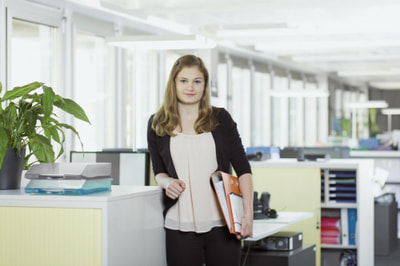 Junge Frau mit Ordnern im Büro Junge Frau mit Ordnern im Büro